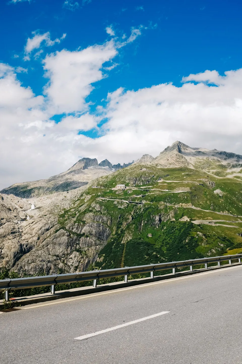 Route alpine au pied de versants rocheux en Suisse